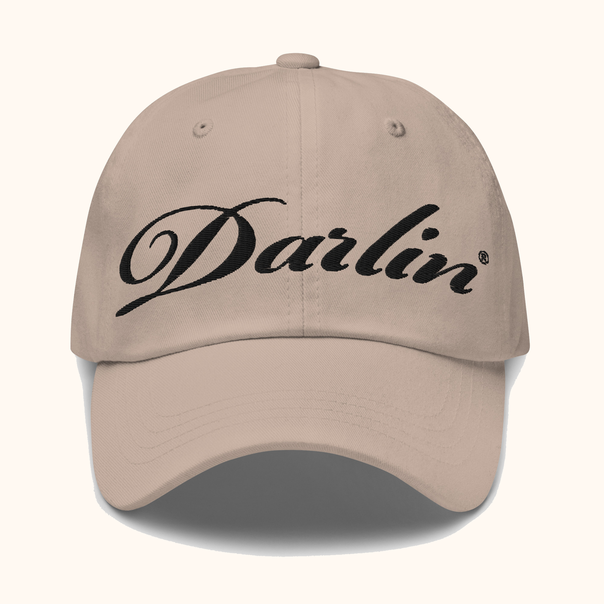 Front view of DARLIN® original script stone hat with black embroidery on a warm ivory background