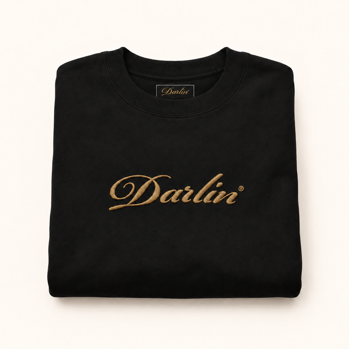 Folded black DARLIN® crewneck with Vintage Gold embroidered script logo