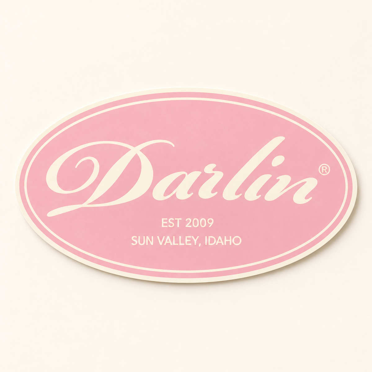 DARLIN® Cream Heritage Oval sticker with Primrose Pink background, cream registered script, EST 2009, and SUN VALLEY, IDAHO.