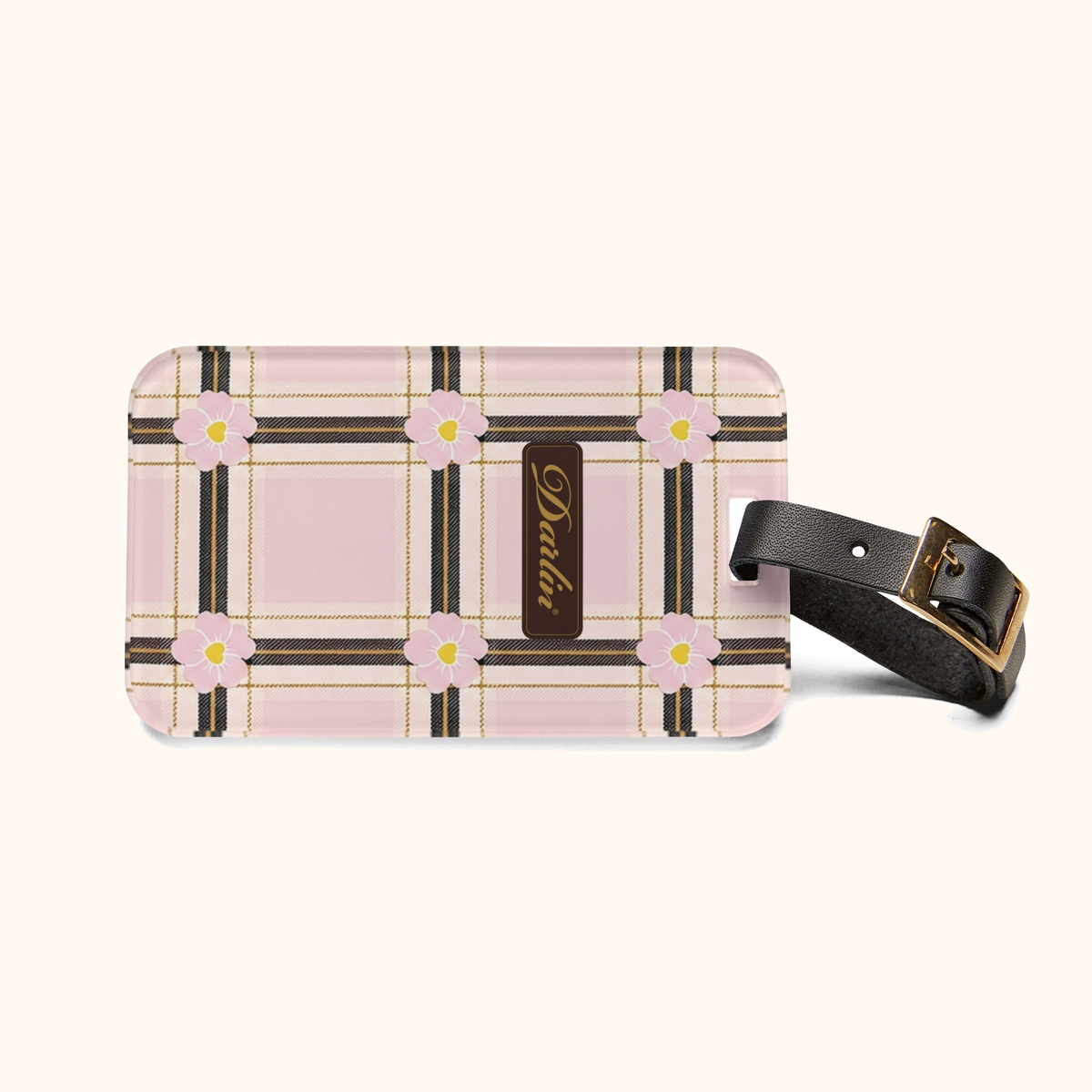 Horizontal view of the DARLIN® Primrose Plaid luggage tag with pink floral plaid, gold script logo, black strap, and brass buckle.