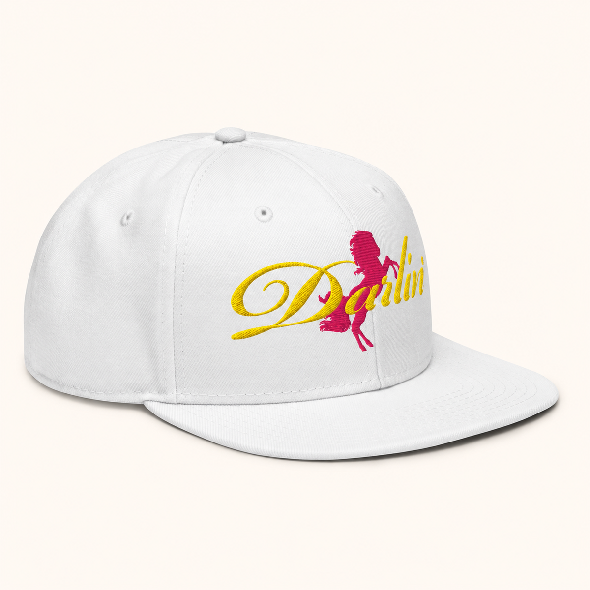 DARLIN® Ride Snapback Hat in white with yellow script and pink pony embroidery – angled view