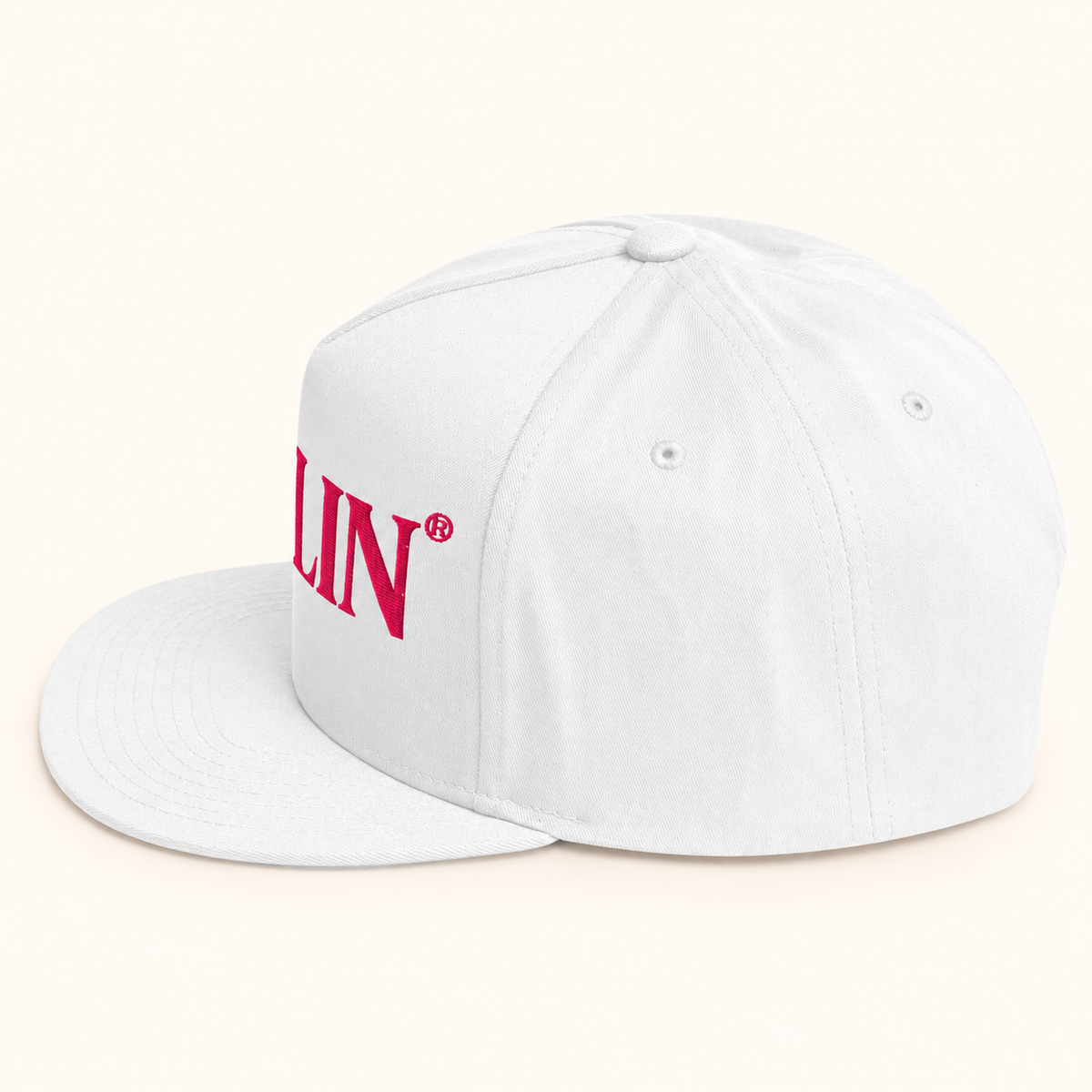 Angled view of white DARLIN® snapback hat with bright pink DARLIN® embroidery