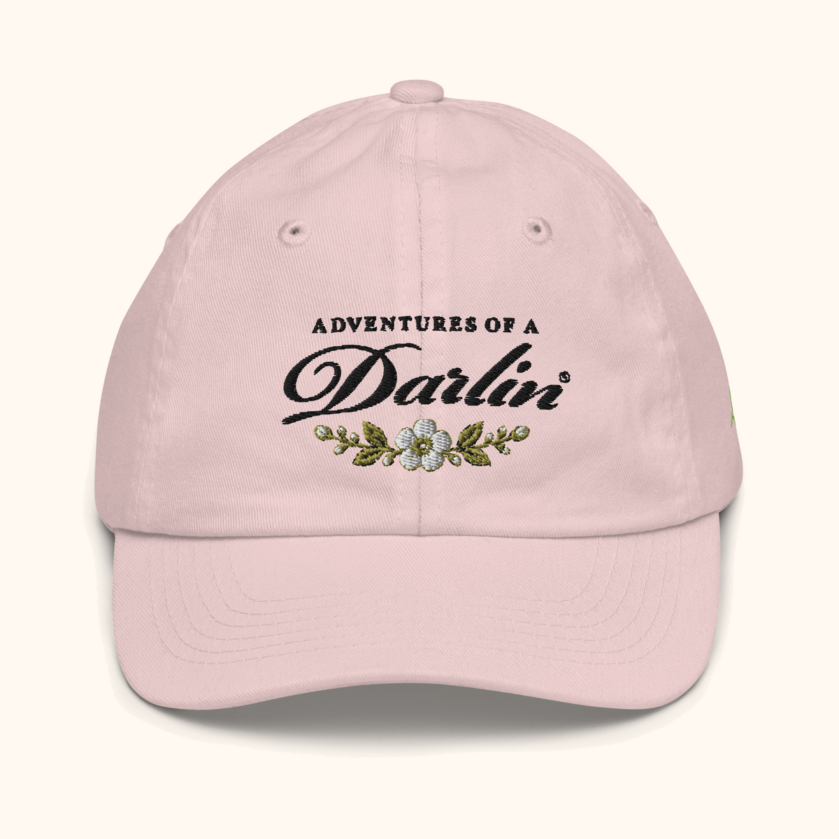 Front view of the Adventures of a DARLIN® kids hat in vintage pink with black script and primrose floral embroidery.