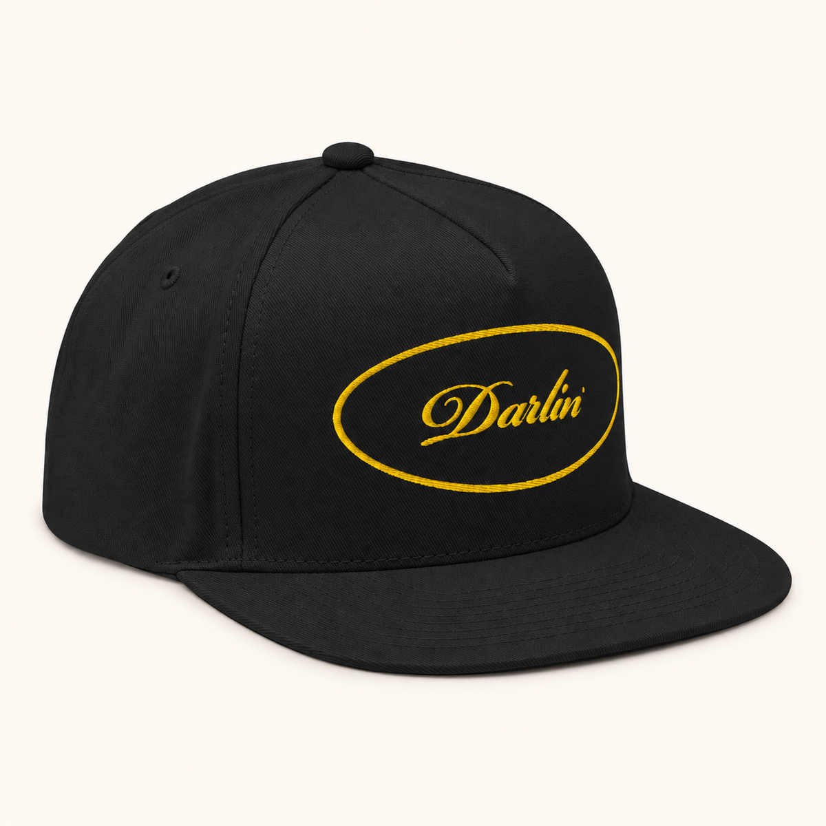 DARLIN® Gold Oval Snapback Hat in black with gold script embroidery – angled view
