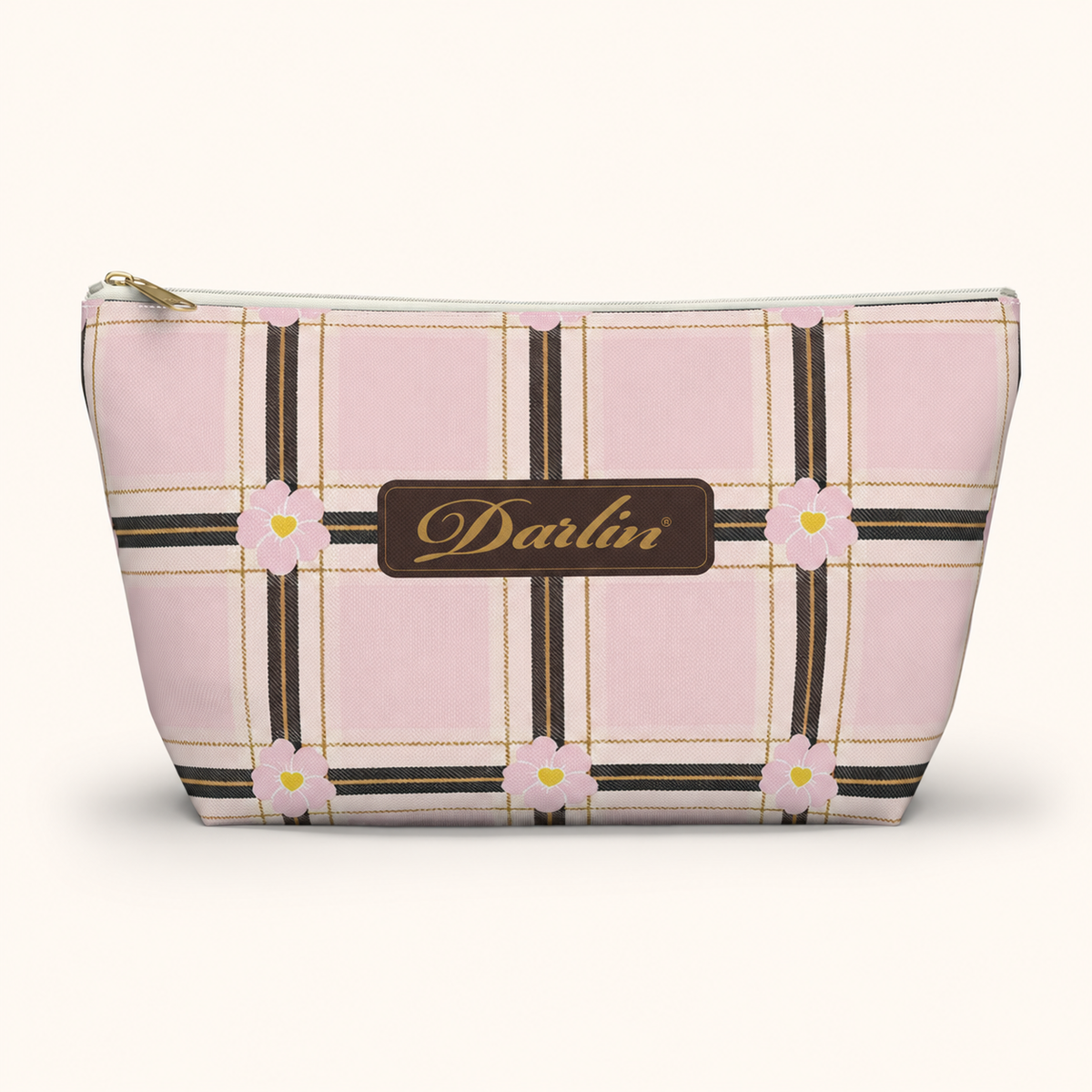 Front view of the DARLIN® Primrose Plaid Travel Pouch with pink floral plaid, chocolate-and-gold registered script, and a white zipper with gold-tone puller.