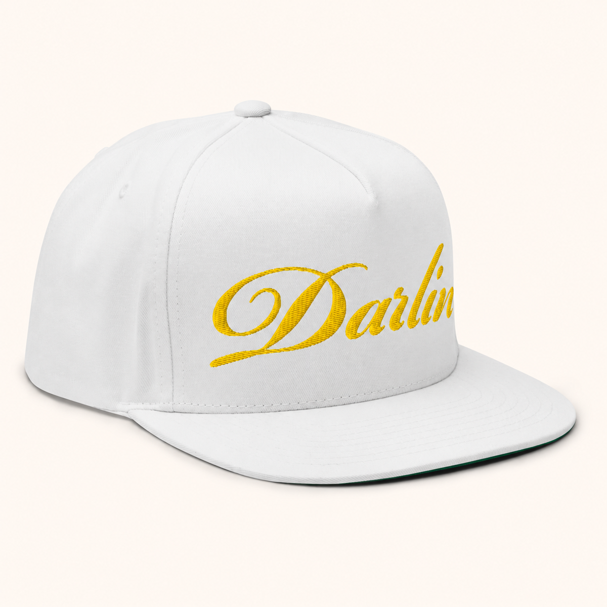 White snapback hat with yellow embroidered DARLIN® script logo, angled view
